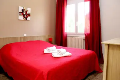 a red bed with two towels on top of it at Accendi Pipa in Campitello