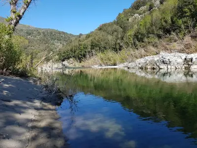 a river with reflections in the water at Accendi Pipa in Campitello