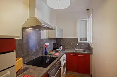 a small kitchen with red cabinets and a sink at Villa Kalliste in Porto Ota
