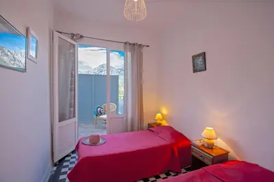 a bedroom with two red beds and a window at Villa Kalliste in Porto Ota