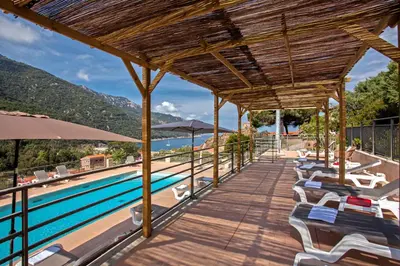 a resort with a swimming pool with chairs and umbrellas at Villa Kalliste in Porto Ota