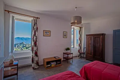 a living room with a red couch and a large window at Gîte Du Pont - Piana in Piana