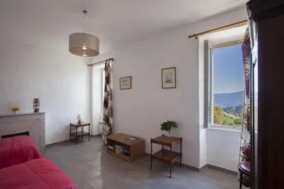 a living room with a red couch and a window at Gîte Du Pont - Piana in Piana