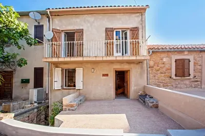 an old house with a balcony and a patio at Gîte Du Pont - Piana in Piana