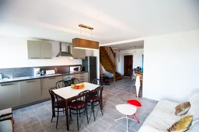 a kitchen and a living room with a table and chairs at Gîte Du Pont - Piana in Piana