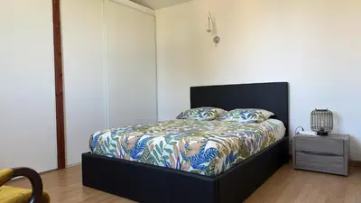 a bedroom with a bed with a colorful comforter at Appartement Maenat in Borgo