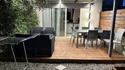 a wooden deck with a table and chairs on it at Appartement Maenat in Borgo