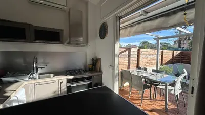 a kitchen with a view of a patio with a table at Appartement Maenat in Borgo