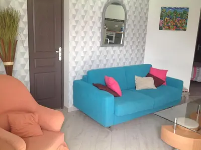 a blue couch with pink pillows in a living room at Apartement Alba Oletta in Oletta