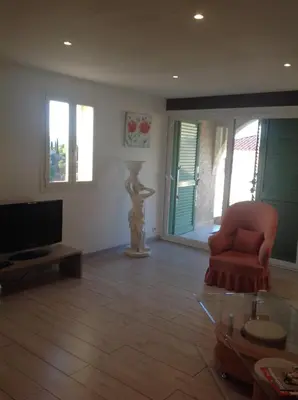 a living room with a chair and a television at Apartement Alba Oletta in Oletta