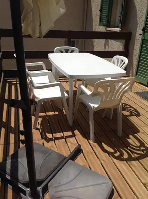 a white table and chairs on a deck at Apartement Alba Oletta in Oletta