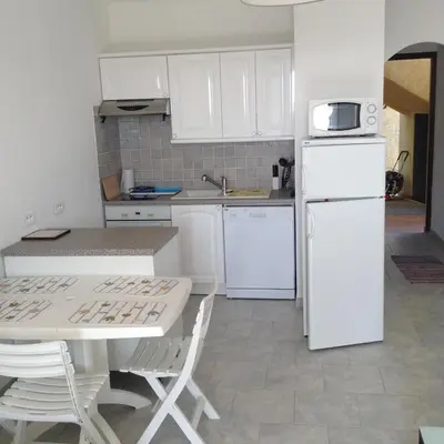 a kitchen with white cabinets and a white refrigerator at Panoramic Seaview studio Tiuccia in Casaglione