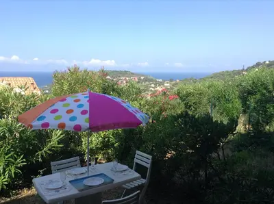 a table with a polka dot umbrella and chairs at Panoramic Seaview studio Tiuccia in Casaglione