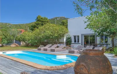 a swimming pool in a yard with a house at Gorgeous Home In Figari in Figari