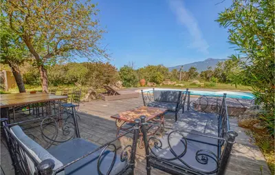 a patio with a table and chairs and a pool at Gorgeous Home In Figari in Figari