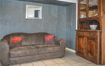 a living room with a brown couch and a wooden cabinet at Gorgeous Home In Figari in Figari