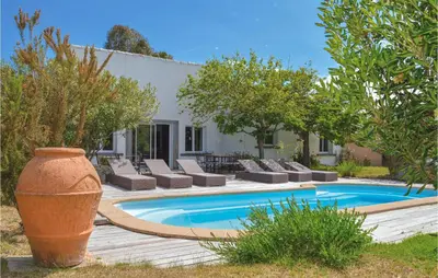 a swimming pool with lounge chairs next to a house at Gorgeous Home In Figari in Figari