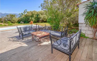 a patio with two chairs and a table on a deck at Gorgeous Home In Figari in Figari