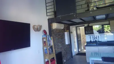 a living room with a tv on a wall at RESIDENCE U RE D' ALZETTU in Porto-Vecchio