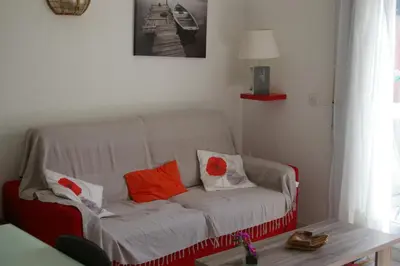 a living room with a white couch with orange pillows at RESIDENCE U RE D' ALZETTU in Porto-Vecchio