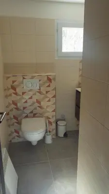 a small bathroom with a toilet and a window at RESIDENCE U RE D' ALZETTU in Porto-Vecchio