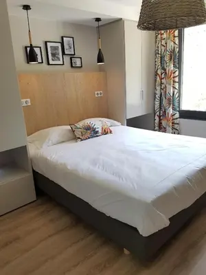 a bedroom with a large white bed in a room at Hôtel de la Restonica in Corte