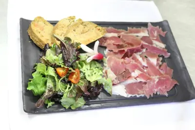 a plate of food with a salad and chips at Hôtel de la Restonica in Corte