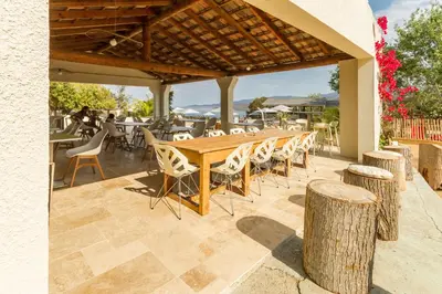 a wooden table and chairs on a patio at Camping Corsica Paradise in Calcatoggio