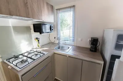 a small kitchen with a stove and a sink at Camping Corsica Paradise in Calcatoggio