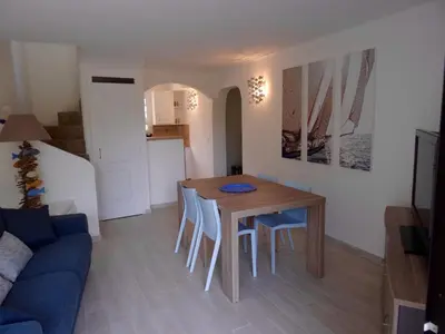 a kitchen and dining room with a table and chairs at Villa 8 au Village Marin in Porto-Vecchio