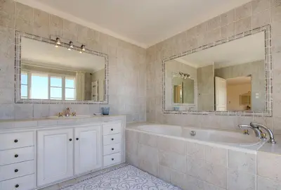 a bathroom with a tub and a large mirror at Casa di Andria in Pietrosella