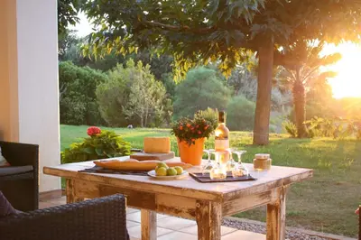 a wooden table with food and a bottle of wine at Casa di Andria in Pietrosella