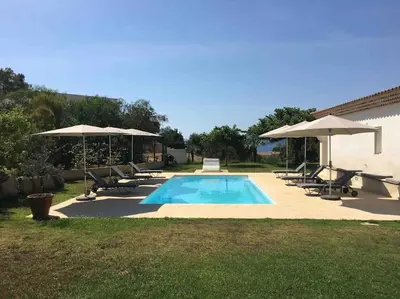 a swimming pool with umbrellas and chairs at Casa di Andria in Pietrosella