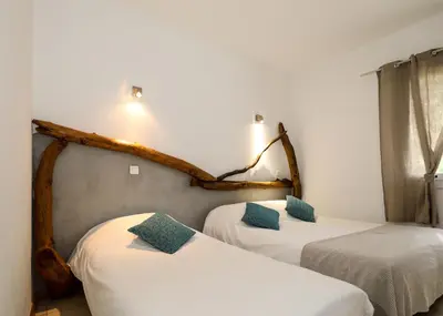 a room with two beds with white sheets and green pillows at Macchie e Fiori in Pianottoli-Caldarello