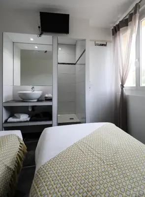 a bedroom with a bed and a bathroom with a sink at Macchie e Fiori in Pianottoli-Caldarello