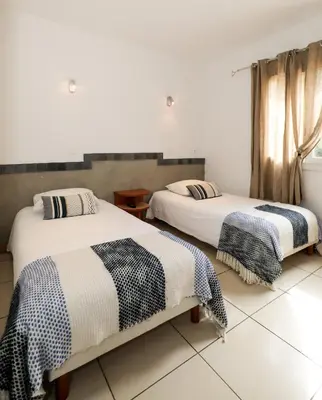 two beds in a room with white walls at Macchie e Fiori in Pianottoli-Caldarello