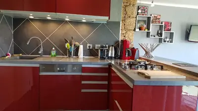 a kitchen with red cabinets and a sink at A Mandria in Porticcio
