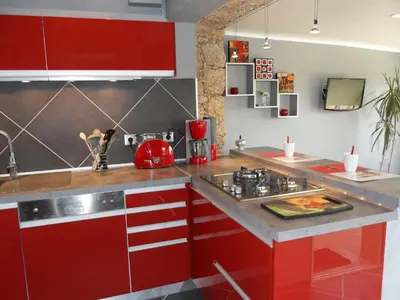 a kitchen with red cabinets and a sink at A Mandria in Porticcio