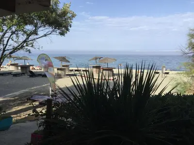 a view of a beach with tables and umbrellas at Les Marines de Morian in Moriani Plage