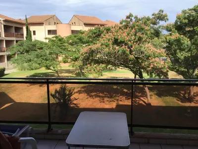 a table sitting on a balcony with a view of a yard at Les Marines de Morian in Moriani Plage
