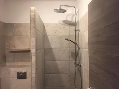 a shower with a glass door in a bathroom at Maredda 1 in Sartène