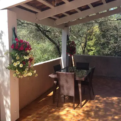 a patio with a table and chairs and flowers at Maredda 1 in Sartène