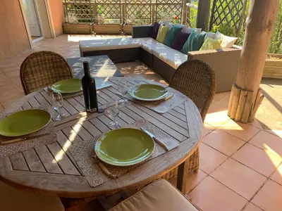 a wooden table with green plates and a bottle of wine at Villa Pampasgiolu in Tizzano