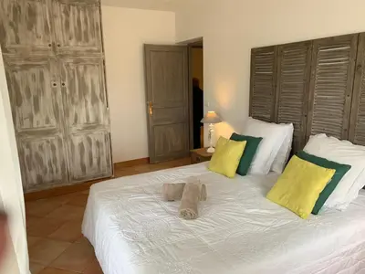 a bedroom with a large white bed with yellow and green pillows at Villa Pampasgiolu in Tizzano