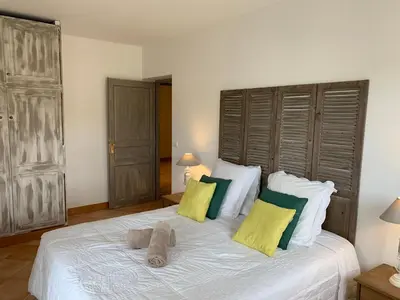 a bedroom with a white bed with yellow and green pillows at Villa Pampasgiolu in Tizzano
