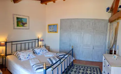 a bedroom with a bed with blue and white pillows at Villa Vetricella Corse Sud in Olmeto
