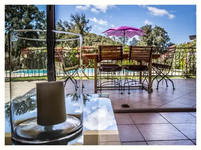 a patio with a table and chairs and an umbrella at Villa 4 étoiles Sole di Corsica in Cauro