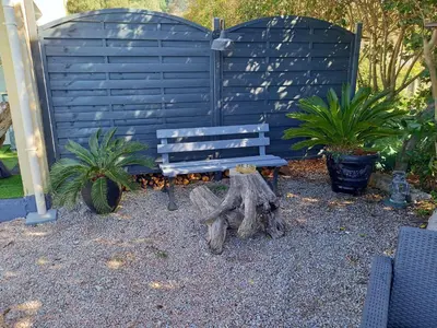 a blue bench in a garden with two plants at A Casa di Mariano in Alata