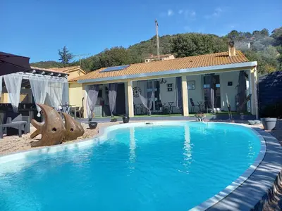 a large blue swimming pool in front of a house at A Casa di Mariano in Alata