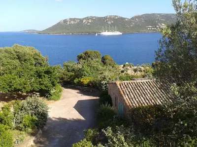 a view of the ocean with a ship in the distance at Résidence Les Pavillons du Belvédère in Porto-Vecchio